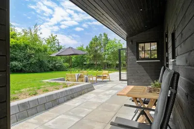 a patio with a table and an umbrella at JB330-Fjerritslev-Perikumvej-12 in Fjerritslev
