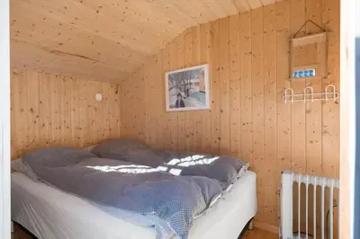 a bedroom with a bed in a wooden wall at JB195-Fjerritslev-Bogevej-36 in Fjerritslev