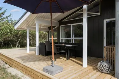 a patio with a table and an umbrella at JB260-Fjerritslev-Blabaerstien-76 in Fjerritslev