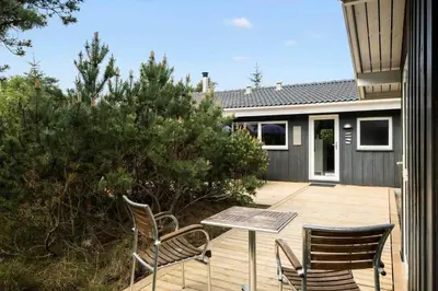 a patio with two chairs and a table on a deck at JB260-Fjerritslev-Blabaerstien-76 in Fjerritslev