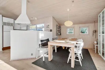 a dining room with a table and a kitchen at JB260-Fjerritslev-Blabaerstien-76 in Fjerritslev