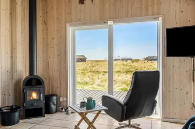 a living room with a chair and a fireplace at JB230-Frostrup-Grabakkevej-4 in Frøstrup