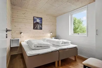 a bedroom with a bed with white sheets and a window at JB350-Fjerritslev-Egevej-9 in Fjerritslev
