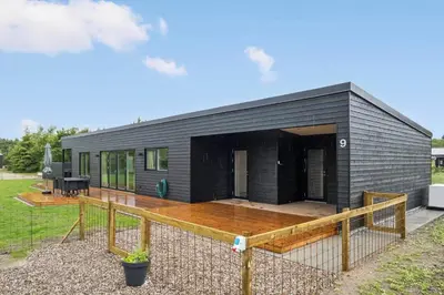 a black tiny house with a wooden deck at JB350-Fjerritslev-Egevej-9 in Fjerritslev