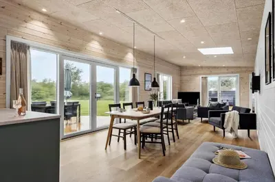 a dining room and living room with a table and chairs at JB350-Fjerritslev-Egevej-9 in Fjerritslev