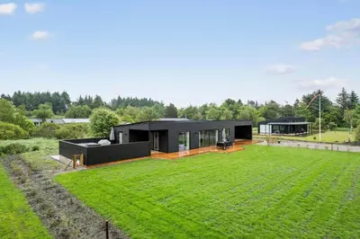 a black house with a large lawn in front of it at JB350-Fjerritslev-Egevej-9 in Fjerritslev