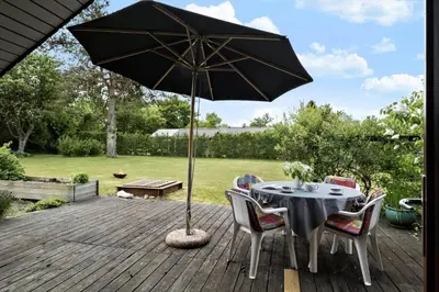 a table and chairs with an umbrella on a deck at JB361-Fjerritslev-Lyngbjergvej-58 in Fjerritslev