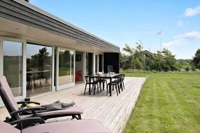 a wooden deck with a table and chairs on it at JB359-Brovst-Kronvildtvej-242 in Brovst