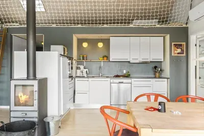 a kitchen with a table and a fireplace in it at JB359-Brovst-Kronvildtvej-242 in Brovst