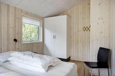 a bedroom with a bed and a chair and a window at JB351-Fjerritslev-Revlingestien-77 in Fjerritslev