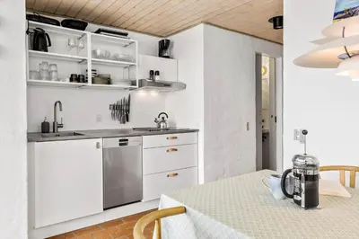 a kitchen with white cabinets and a table at JB358-Brovst-Strandvejen-150-Lejl-126 in Brovst