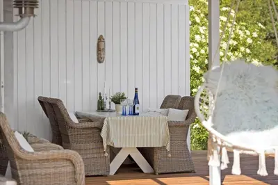 a patio table with wicker chairs and bottles of wine at JB401-Brovst-Solsortevej-1 in Brovst