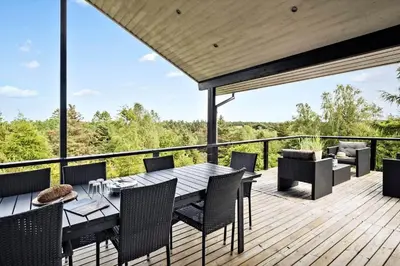a wooden deck with a table and chairs on it at JB400-Brovst-Solsortevej-7 in Brovst