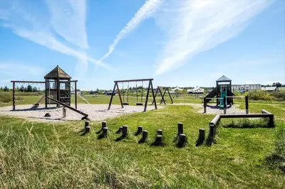 an empty playground with two swings in a field at JB316-Brovst-Kronvildtvej-250 in Brovst