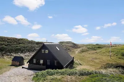 a black house sitting on top of a hill at 850-Thisted-Sandvej-19 in Thisted