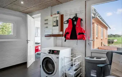 a laundry room with a washing machine and a window at 2 Bedroom Amazing Home In Thyholm in Thyholm