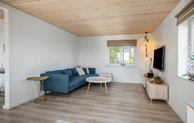 a living room with a blue couch and a table at 2 Bedroom Amazing Home In Thyholm in Thyholm