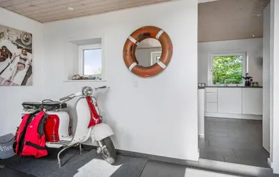 a red and white scooter parked in a room at 2 Bedroom Amazing Home In Thyholm in Thyholm