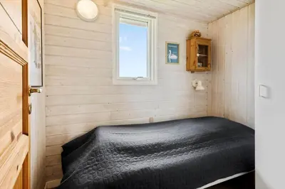 a black bed in a small room with a window at G228-Lemvig-Myntevej-28 in Lemvig