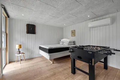 a bedroom with a bed and a stove in it at LK2185-Lokken-Marthinesvej-17 in Løkken