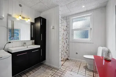 a bathroom with a sink and a toilet and a window at LK2185-Lokken-Marthinesvej-17 in Løkken