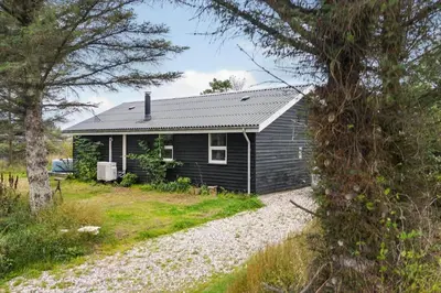 a small house with a gravel road in front of it at LK2185-Lokken-Marthinesvej-17 in Løkken