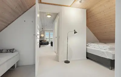 a small attic bedroom with a bed and a lamp at Pet Friendly Home In Vestervig With Sauna in Vestervig