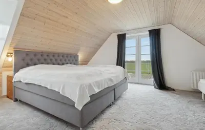 a bedroom with a large bed and a large window at Pet Friendly Home In Vestervig With Sauna in Vestervig