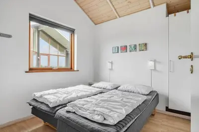 a large bed in a room with a window at 70721-Ulfborg-Klitengene-11 in Ulfborg