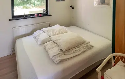 a bed with three pillows on it in a room at Pet Friendly Home In Struer With Wifi in Struer