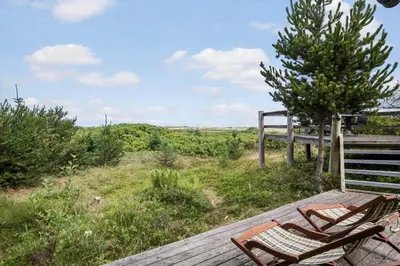 a deck with two chairs and a tree at JB363-Fjerritslev-Tolderstien-8 in Fjerritslev