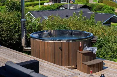 a hot tub sitting on top of a wooden deck at G322-Lemvig-Gyvelvej-22 in Lemvig