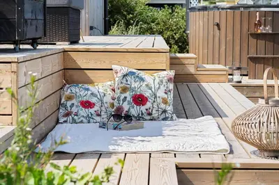 a bench with two pillows on a wooden deck at G322-Lemvig-Gyvelvej-22 in Lemvig