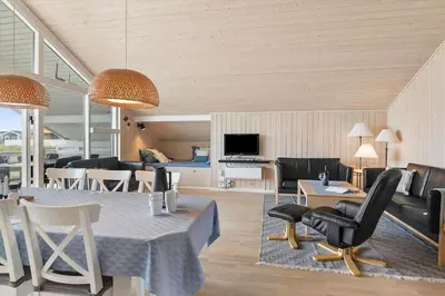 a living room with a table and chairs and a couch at 814-Harboore-Neerlandiavej-176 in Harboør