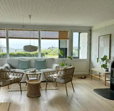 a living room with a couch and a table at Beach Hotel Inspired Holiday Home By Limfjorden in Snedsted