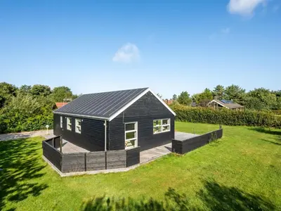 a black tiny house on a grass field at Holiday Home Anja - 550m to the fjord by Interhome in Vemb