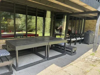 a wooden bench sitting outside of a building at Holiday Home Karmen - 1km from the sea by Interhome in Pandrup