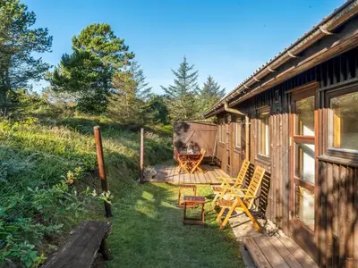 a porch of a cabin with a table and chairs at Holiday Home Anneka - 750m from the sea by Interhome in Pandrup