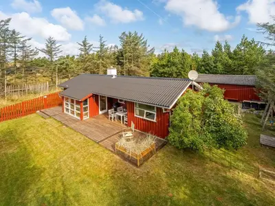 an aerial view of a red house with a deck at Holiday Home Ingobert - 600m from the sea by Interhome in Saltum