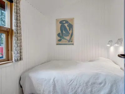 a bedroom with a white bed and a painting on the wall at Holiday Home Ingobert - 600m from the sea by Interhome in Saltum