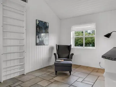 a chair sitting in a room with a window at Holiday Home Alde - 150m from the sea by Interhome in Blokhus