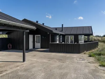 a black house with a driveway in front of it at Holiday Home Alde - 150m from the sea by Interhome in Blokhus
