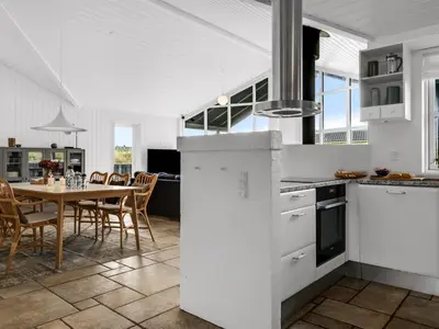 a kitchen and dining room with a table and chairs at Holiday Home Alde - 150m from the sea by Interhome in Blokhus