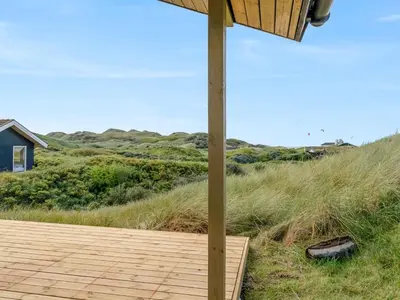 a wooden deck with a view of the ocean at Holiday Home Myrna - 250m from the sea by Interhome in Saltum