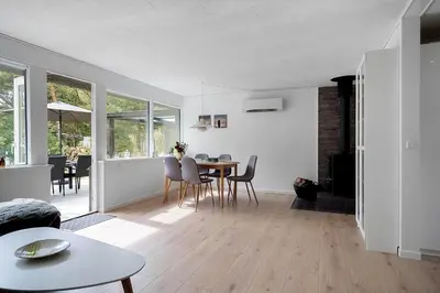 a dining room and living room with a table and chairs at 1357-Snedsted-Grahavrevej-1 in Snedsted
