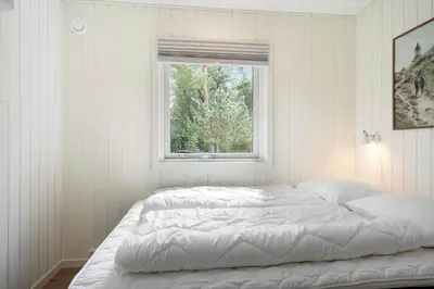 a white bedroom with a bed and a window at 1357-Snedsted-Grahavrevej-1 in Snedsted