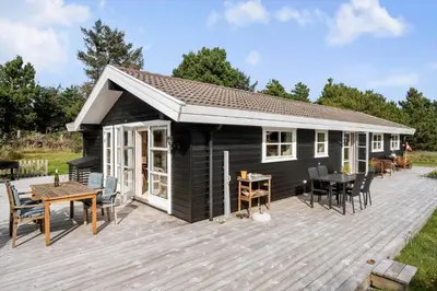 a black tiny house with a wooden deck at BL1121-Saltum-Daadyrvej-7 in Saltum