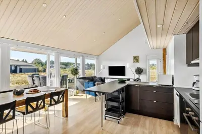 a kitchen and dining room with a table and chairs at JB367-Brovst-Kronvildtvej-102 in Brovst