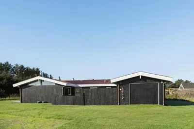 a house with a black garage in a field at LK2192-Lokken-Magdalenevej-18 in Løkken