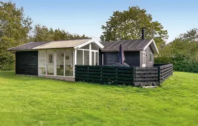 a small house in a field with a grass yard at Awesome Home In Farsø With Sauna in Farsø